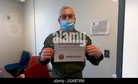 Oberst Mark Morginstin, ein Flugchirurg der 111. Medizinischen Gruppe in Pennsylvania, posiert mit einem Schild, das erklärt, warum er sich für die COVID-19-Impfung auf der Biddle Air National Guard Base entschieden hat, 6. März 2021. Morginstin gehört zu den 320 Mitgliedern des 111. Angriffsflügels, die ihre zweite Dosis des COVID-19 auf Basis erhielten. ( Stockfoto