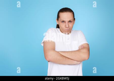 Junger Mann runzelte isoliert auf blauem Hintergrund die Stirn. Menschliche Emotionen, Gesichtsausdrücke Stockfoto