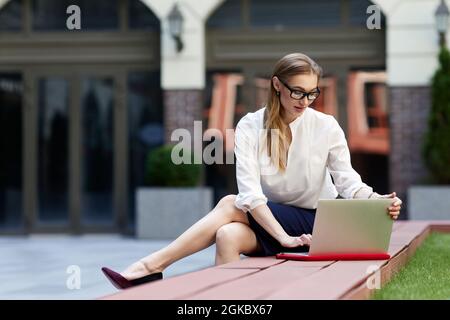 Geschäftsfrau, die im Freien am Computer arbeitet Stockfoto