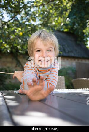 Porträt von niedlichen positiv freundlich lachenden Jungen 5 Jahre alt im Freien. Viel Spaß in der Kindheit. Herumtäuschen, Spaß haben. Stockfoto