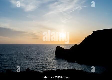 Sonnenuntergang an einem schönen Frühlingstag mit ruhigem Meer, von Anchor Bay, Mellieha, Malta aus gesehen. Stockfoto