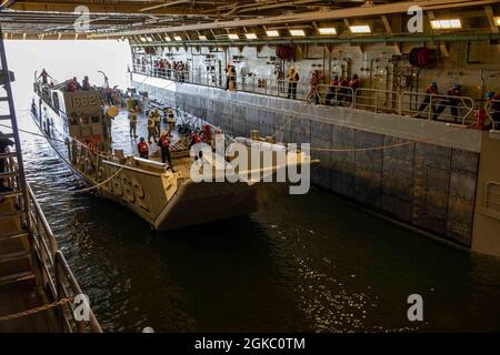 210308-N-PC065-1082 ATLANTISCHER OZEAN (8. März 2021) Seeleute, die dem amphibischen Transportschiff USS Arlington (LPD 24) der San Antonio-Klasse zugewiesen wurden, führen Bohrdeckeloperationen mit Landing Craft Utility (LCU 1662) durch, 8. März 2021. Arlington ist im Atlantischen Ozean unterwegs. Stockfoto