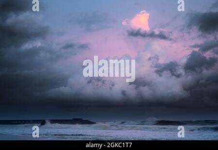 Farbenprächtiger rosa-violetter Sonnenuntergang am Strand von Galle, dunkle Wolken am Horizont. Wunderschöne Strände auf der Insel Sri Lanka. Stockfoto