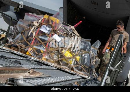 Flieger des 8. Expeditionary Air Mobility Squadron helfen beim Entladen von Fracht aus einem C-130H Hercules, der dem 332. Air Expeditionary Wing auf der Al Udeid Air Base, Katar, zugewiesen wurde, 3. März 2021. Der C-130H war Teil einer integrierten Kampfturnentrainingsveranstaltung mit F-15E Strike Eagles, die schnelle Einsatzfähigkeiten zum Schutz des Verantwortungsbereichs des US Central Command einsetzte. Stockfoto