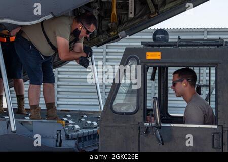 Flieger des 8. Expeditionary Aircraft Maintenance Squadron helfen beim Entladen von Fracht aus einem C-130H Hercules, der dem 332. Air Expeditionary Wing auf der Al Udeid Air Base, Katar, zugewiesen wurde, 3. März 2021. Der C-130H war Teil einer integrierten Kampfturnentrainingsveranstaltung mit F-15E Strike Eagles, die schnelle Einsatzfähigkeiten zum Schutz des Verantwortungsbereichs des US Central Command einsetzte. Stockfoto