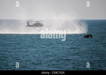 MARINESTATION ROTA, Spanien (9. März 2021) Ein Such- und Rettungsschwimmer (SAR) fällt während eines SAR-Schwimmertrainings auf der Naval Station (NAVSTA) Rota, Spanien, 9. März 2021 von einem MH-60R Seahawk-Hubschrauber, der der Helicopter Maritime Strike Group (HSM) 79 zugewiesen wurde, ins Wasser. Stockfoto