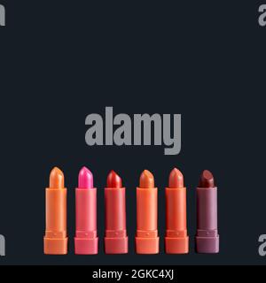 Set von Mode Lippenstifte Palette in rot, braun und rosa Farben, Studio-Foto auf schwarzem Hintergrund. Schönes Make-up oder kosmetisches Verkaufskonzept Stockfoto