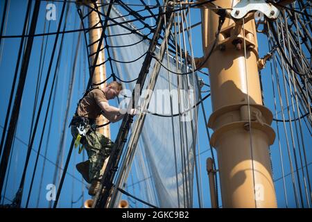 ATLANTISCHER OZEAN (10. März 2021) der Seemann der US-Marine, Justin Howell, besteigt die Schutzhüllen an Bord des USCGS Eagle (WJX 327), während er im Atlantischen Ozean unterwegs ist. Matrosen, die der USS Constitution zugewiesen wurden, sind mit Eagle unterwegs, um in der Segelkunst geschult zu werden und die Beziehungen zwischen Marine und Küstenwache weiter auszubauen. Stockfoto