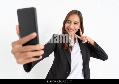 Schöner Geschäftsmann im schwarzen Anzug lächelnd, wenn er Selfie mit der Handykamera nimmt Stockfoto
