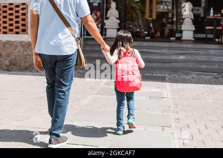 Vater geht mit seiner Tochter zur Schule Stockfoto