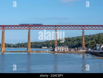 South Queensferry, Edinburgh, Schottland 7. September 2021 - Blick auf eine Scotrail Class 158 DMU auf der Forth Rail Bridge mit einer Lifeboat Station unten Stockfoto