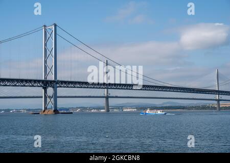 South Queensferry, Edinburgh, Schottland 7. September 2021 - Blick auf die Forth Road Bridge und Queensferry Überfahrt mit einem Fährboot an einem sonnigen Tag Stockfoto