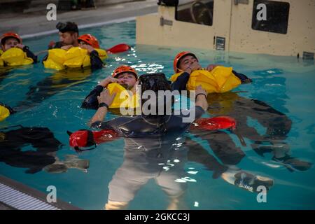 U.S. Marines with Alpha Company, 2d Assault Amphibian Bataillon, 2d Marine Division, Proben Ausgangs-Techniken von einem sinkenden Angriff amphibischen Fahrzeug während eines Unterwasser Ausgangs Training auf Camp Lejeune, N.C., 11. März 2021. Unterwasser-Ausstieg-Training ist ein lebensrettender Kurs, der Service-Mitglieder mit den Fähigkeiten und dem Selbstvertrauen, um erfolgreich und sicher entfernen sich aus einem Angriff amphibischen Fahrzeug, leichte gepanzerte Fahrzeuge und Hubschrauber, die in Wasser getaucht werden können. Stockfoto