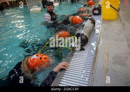 U.S. Marines with Alpha Company, 2d Assault Ampphibian Battalion, 2d Marine Division, gewinnen Vertrauen mit Druckluft unter Wasser während eines Unterwasser-Ausstiegstrainings auf Camp Lejeune, N.C., 11. März 2021. Unterwasser-Ausstieg-Training ist ein lebensrettender Kurs, der Service-Mitglieder mit den Fähigkeiten und dem Selbstvertrauen, um erfolgreich und sicher entfernen sich aus einem Angriff amphibischen Fahrzeug, leichte gepanzerte Fahrzeuge und Hubschrauber, die in Wasser getaucht werden können. Stockfoto