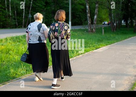 Frauen in Russland gehen die Straße hinunter. Wandelige ältere Frauen in schwarzen Kleidern. Stadtleben. Die Menschen gehen entlang der Fußgängerzone. Stockfoto