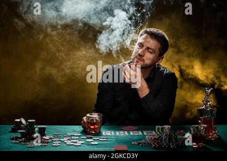 Bärtiger Casino Spieler Mann, der Poker auf dem grünen Tisch spielt Stockfoto