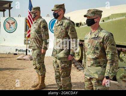 Kommandant der Task Force Spartan, Maj. Gen. Patrick Hamilton, steht mit dem Kommandanten der 2. Panzerbrigade, Oberst Michael Wagner, und Command Sgt. Maj. Christopher Kohunsky, während einer Farbsteinzeremonie im Lager Buehring in Kuwait, 11. März 2021. Hamilton überwachte die Zeremonie, die den Abschied einer Einheit von einer Mission und die Neuzuweisung zu einer neuen Mission symbolisiert. Stockfoto
