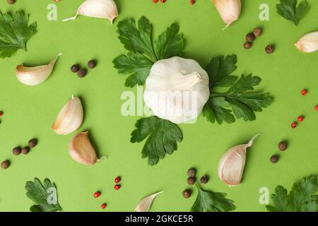 Knoblauch, Petersilie und Gewürze auf grünem Hintergrund Stockfoto