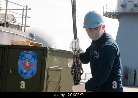 SAGAMI WAN (11. März 2021) - Informationssystemtechniker der 3. Klasse Enge-Leon Dorsey aus Las Vegas wickelt während einer Munitionsaufladung auf dem US-Flaggschiff USS Blue Ridge (LCC 19) eine Kranlinie ab. Blue Ridge ist das älteste operationelle Schiff der Marine und arbeitet als Kommandoschiff der 7. Flotte aktiv an der Förderung von Beziehungen zu Verbündeten und Partnern in der Indo-Pazifik-Region. Stockfoto