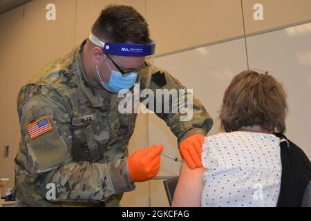 Pfc. Jonathan Miller, ein Kampfmediziner der Headquarters and Headquarters Company, 2/112. Infanterie-Regiment, Pennsylvania National Guard, verabreicht am 12. März 2021 einen COVID-19-Impfstoff bei der Lancaster-Lebanon IU13 in Lancaster, Pennsylvania. Fast 90 Mitglieder der Nationalgarde von Pennsylvania unterstützen COVID-19-Impfkliniken für Lehrer und Schulpersonal an sieben Standorten in Pennsylvania. Stockfoto