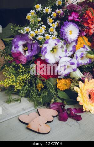 Ein Hochzeitsbouquet von Sommerblumen mit Liebesherz-Dekorationen vorne Stockfoto