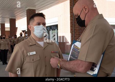 Captain Stephen Douglas Stephens, Kommandant der Naval Health Clinic Cherry Point, würdigt den Hospitalmann Marcus Ribas aus Sioux Falls, South Dakota, während einer Zeremonie an Bord der Klinik am Freitag, dem 12. März 2021, mit der Medaille für das Erreichen des Marine- und Marine-Korps. Stockfoto