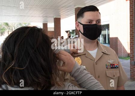 Die Frau des Petty Officers 3rd Class Edgar Sarabiafigueroa aus Los Angeles, Kalifornien, hält seinen neu beförderten Rang während einer Zeremonie am Freitag, den 12. März an Bord der Marine Corps Air Station Cherry Point fest. Zahlreiche Seeleute erhielten Auszeichnungen für ihre Beiträge zur Mission der Klinik, die medizinische Bereitschaft von MCAS Cherry Point zu unterstützen, während andere Rang in Anerkennung ihres Potenzials, in Aufgaben mit erhöhter Herausforderung und Verantwortung erfolgreich zu sein, weiter entwickelten. Stockfoto