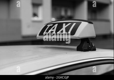 Taxi-Schild auf einem deutschen Taxi von rechts in schwarz-weiß Stockfoto