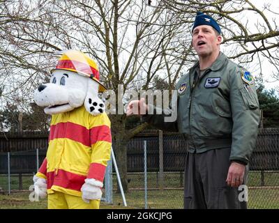 Col. Jason Camilletti, Kommandant des 48th Fighter Wing, spricht bei einer Zeremonie zum Schneiden von Bändern für den Hundepark Liberty Paws neben Sparky the Firedog, Maskottchen der 48th Fighter Wing Fire Department, in der Royal Air Force Lakenheath, England, am 13. März 2021. Vom Konzept bis zur Realität dauerte das Hundepark-Projekt Liberty Paws nur knapp fünf Monate und beinhaltet einen Agility-Kurs für Hunde aller Größen. Stockfoto