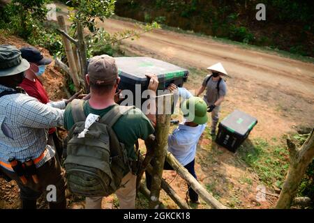 US-Dienstmitglieder, die einem Bergeteam der Verteidigungsgefangenen/MIA Accounting Agency (DPAA) zugewiesen wurden, heben während der Operationen in der Provinz Ha Tinh, Vietnam, 14. März 2021, Aushubgeräte über einen Holzzaun. Die Mission der DPAA ist es, die bestmögliche Rechenschaft über vermisste und nicht bilanzierte US-Mitarbeiter für ihre Familien und unser Land zu erlangen. Stockfoto