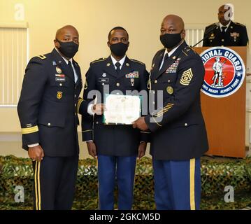 Brig. General Kodjo Knox-Limbacker (links), der Adjutant General der Nationalgarde der Jungferninseln, und Command Sgt. Major Kent Bellot (rechts), Kommandofeldwebel Major, überreicht die Ehrenmedaille der Armee an Staff Sgt. Daniel Nibbs während eines Mittagessens, das am Sonntag, den 14. März 2021, im Restaurant des 210. Regionalen Trainingsinstituts stattfand. Der VING-BWC ist ein kulminierender Test, bei dem die konkurrierenden Unteroffizierinnen und Soldaten fünf Tage lang an verschiedenen Herausforderungen teilnehmen, darunter das Abfeuern von Waffen, die Landnavigation, den Army Physical Fitness Test und andere verschiedene Veranstaltungen. Diese Herausforderungen werden jede c Stockfoto