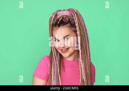 Frau mit Dreadlocks lächelt auf grünem Hintergrund Stockfoto