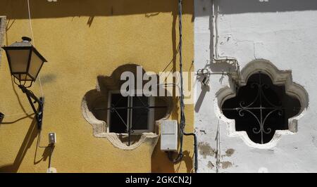 Alte Lampe an der Wand neben runden Fenstern, Cädaz, Spanien Stockfoto