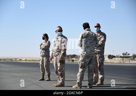 Die italienischen Luftstreitkräfte sprechen während eines Betoneingießens auf der Ali Al Salem Air Base, Kuwait, 14. März 2021. Die Mitglieder der 386. Expeditionary Civil Engineer Squadron arbeiteten mit Joint- und Koalitionspartnern zusammen, um mit dem Aufbau eines mobilen Luftfahrtingenieursystems zu beginnen. Die MAAS ist ein Notbremssystem für Flugzeuge mit Heckhaken. Stockfoto