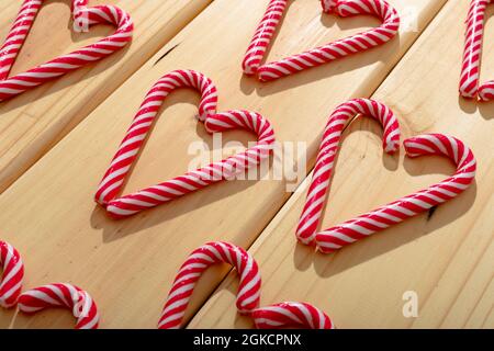 Komposition aus mehreren Zuckerstöcken in Herzform auf Holzhintergrund Stockfoto