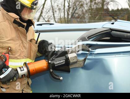 US Air Force Airman 1st Class Benjamin Bergeron, 100. Zivilingenieur-Squadron Feuerwehrmann, nutzt die Jaws of Life, um während eines simulierten Autounfalls und Torläuferszenarios im Rahmen einer Übung bei der Royal Air Force Mildenhall, England, am 16. März 2021 das Dach eines Autos abzuschneiden. Die Übung bestand aus einer Vielzahl von Szenarien, um das EM der Basis zu testen Stockfoto