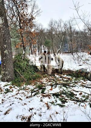 Die Kursteilnehmer der Kurs-Klasse 21-05 für Kaltwettereinsätze führen Feldtraining mit improvisierten Unterkünften durch, darunter mit dem hier gezeigten, 16. März 2021, in einem Trainingsbereich in Fort McCoy, Wis. die CWOC-Studenten werden in einer Vielzahl von Themen für kaltes Wetter geschult. Einschließlich Schneeschuhtraining und Skifahren sowie wie man ahkio Schlitten und andere Ausrüstung verwendet. Das Training konzentriert sich auch auf Gelände- und Wetteranalysen, Risikomanagement, Kaltwetterkleidung, die Entwicklung von Winterkampfpositionen im Feld, Tarnung und Verschleierung sowie zahlreiche andere Bereiche, die für das Überleben und die Operation wichtig sind Stockfoto