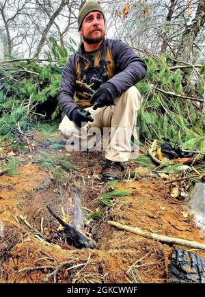 Instructor Brian Seamann hilft den Kursteilnehmern der Kurs-Klasse 21-05 für Kaltwettereinsätze bei der Durchführung von Feldtrainings mit improvisierten Unterkünften, einschließlich des hier gezeigten, 16. März 2021, in einem Trainingsbereich in Fort McCoy, Wis. CWOC-Studenten werden in einer Vielzahl von Themen für kaltes Wetter geschult, Einschließlich Schneeschuhtraining und Skifahren sowie wie man ahkio Schlitten und andere Ausrüstung verwendet. Das Training konzentriert sich auch auf Gelände- und Wetteranalysen, Risikomanagement, Kaltwetterkleidung, die Entwicklung von Winterkampfpositionen auf dem Feld, Tarnung und Verschleierung sowie zahlreiche andere Bereiche, die wichtig sind Stockfoto
