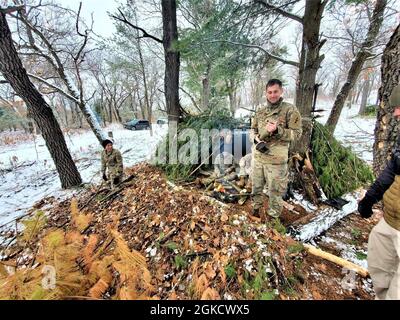 Kursteilnehmer der Kurs-21-05 für Kaltwettereinsätze führen Feldtraining mit improvisierten Unterkünften durch 16. März 2021, in einem Trainingsbereich in Fort McCoy, Wis. die CWOC-Studenten werden in einer Vielzahl von Themen für kaltes Wetter geschult, darunter Schneeschuhtraining und Skifahren sowie die Verwendung von ahkio-Schlitten und anderen Geräten. Die Ausbildung konzentriert sich auch auf Gelände- und Wetteranalysen, Risikomanagement, Kaltwetterkleidung, die Entwicklung von Winterkampfpositionen im Feld, Tarnung und Verheimlichung sowie zahlreiche andere Bereiche, die wichtig sind, um in einer kalten Umgebung zu überleben und zu arbeiten. Stockfoto
