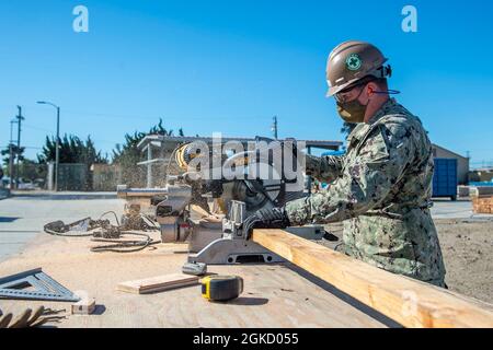 210316-N-TP832-1024 PORT HUENEME, Kalifornien (16. März 2021) der Baumeister der 3. Klasse Riley Harrison, der dem U.S. Naval Mobile Construction Bataillon (NMCB) 3 zugewiesen wurde, schneidet zwei Mal für die Schalung als Teil eines Seabee Technical Training Moduls für erhöhte Plattformen an Bord des Marinestützpunktes Ventura County, Port Hueneme für zukünftige Indo-Pacific Missionen. Seabees sind die Expeditions- und Bauexperten des Marineservice. Sie stellen aufgabengerechte, anpassungsfähige und kampfbereite Konstruktions- und Konstruktionskräfte bereit, die zur Unterstützung der Ziele der Marine weltweit eingesetzt werden. Stockfoto