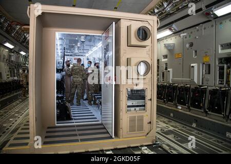 Brig. General (Pilot) Meshaal Al-Nasr, Kommandant der katarischen Emiri Air Force Airlift Group und Brig. General Dan Tulley, Kommandant des 379. Air Expeditionary Wings, tourt während eines Katar-USA-Flugs durch einen negativ druckbelasteten CONEX Air Force Friendship Event auf dem Al Udeid Airbase, 9. März 2021. Die Veranstaltung bot den Mitgliedern des 379. Expeditionary Aeromedical Evacuation Squadron die Gelegenheit, zu zeigen, wie der NPC es Pflegekräften ermöglicht, infektiöse Patienten in einer sicheren und geschlossenen Umgebung zu transportieren und zu behandeln. Die katarische Emiri-Luftwaffe und das Zentralkommando der US-Luftstreitkräfte haben sich einer dauerhaften regiona verschrieben Stockfoto