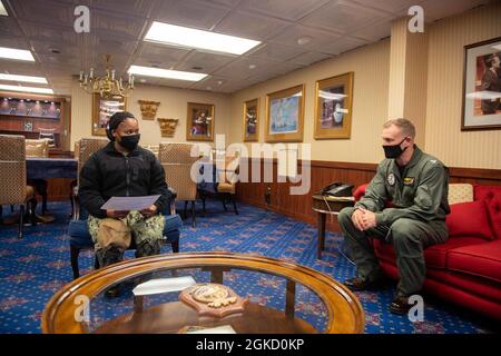 US Navy Capt. Cassidy Norman, rechts, Kommandant des Flugzeugträgers USS John C. Stennis (CVN 74) spricht mit Hospital Corpsman Aquasia Dawkins aus Fort Lauderdale, Florida, dem Warfighter der Woche, während einer Zeremonie in der Hafenkabine des Schiffes in Norfolk, Virginia, am 16. März 2021. John C. Stennis arbeitet mit Newport News Shipbuilding zusammen, um die Überholung des Tankkomplexes planmäßig mit einer geschulten, widerstandsfähigen und geschlossenen Crew abzuschließen. Stockfoto