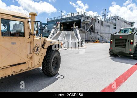 210317-N-WR252-1041 SANTA RITA, Guam (17. März 2021) Seekühe, die dem Marine Mobile Construction Bataillon (NMCB) 4 zugeordnet sind, laden während einer Mount-Out-Übung (MOX) an Bord des Marinestützpunktes Guam die Hilfsausrüstung (CESE) der Bauingenieure an Bord des Spearhead-Klasse-Schnelltransportschiffes USNS Fall River (T-EPF-4). Während der MOX demonstrierten die Seabees ihre CESE-Fähigkeiten und tauschten ihr Wissen mit der Crew des Military Sealift Command (MSC) aus, um die Bereitschaft zu verbessern. NMCB 4 wird im gesamten Indo-Pazifik-Raum und in den Vereinigten Staaten eingesetzt und ist bereit, größere Kampfeinsätze und derat zu unterstützen Stockfoto