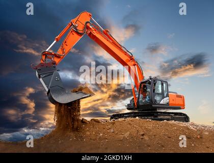 Bagger arbeiten auf der Baustelle mit dramatischen Wolken am Himmel Stockfoto