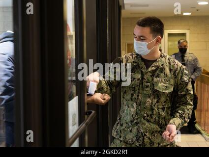 US Navy Petty Officer 3rd Class Jesse Cox, ein Danville, Indiana, einheimischer und Marinetaucher, der der Mobile Diving Salvage Unit 2, Joint Expeditionary Base Little Creek, Virginia, zugeordnet ist, nimmt die Temperatur eines Gemeindemitglieds beim staatlich geführten, staatlich unterstützten York College COVID-19 Community Vaccination Center in Queens, New York, März 17, 2021. Dieses Zentrum geimpft zurückkehrende Gemeindemitglieder mit ihrer zweiten Dosis des COVID-19-Impfstoffs. Das U.S. Northern Command setzt sich über die U.S. Army North weiterhin dafür ein, dem Federal Emer weiterhin flexible Unterstützung durch das Verteidigungsministerium zu leisten Stockfoto