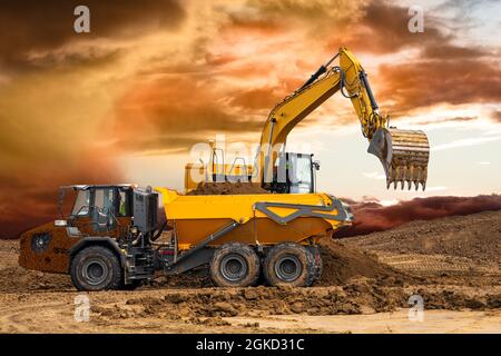 Bagger arbeiten auf der Baustelle mit dramatischen Wolken am Himmel Stockfoto