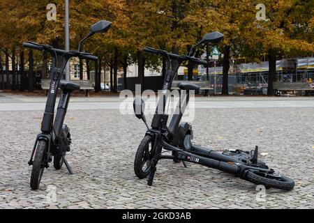 Zwei stehende und ein liegender E-Scooter mit Sitz von Wheels Stockfoto