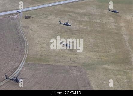Eine Reihe von Apache-Hubschraubern schwebt während der Operation Eminent Strike auf dem Flugplatz der Armee Katterbach, Deutschland, März 17, über dem Boden. Die Schulung wurde entwickelt, um die Reaktionszeit der teilnehmenden Einheiten während eines kritischen Zwischenfalls zu messen. Stockfoto