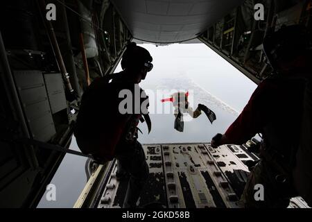 Die dem 38. Rettungsgeschwader zugeordneten Paraskuemen der US-Luftwaffe springen von einem HC-130J Combat King II-Flugzeug in den Banana River in der Nähe der Patrick Space Force Base, Florida, 24. August 2021. Aufgrund der hohen Teamarbeit und der körperlich anspruchsvollen Szenarien, denen pararescuemens begegnen, ist Training für Rettungseinsätze von entscheidender Bedeutung. Stockfoto