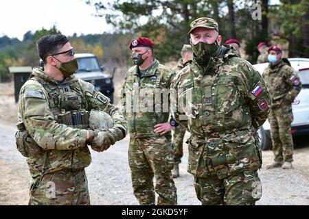 Der US-Armeekapt Quinton K. Brooks, dem 1. Bataillon zugeordneter Fallschirmjäger, 503. Infanterie-Regiment, 173. Luftbrigade, links, spricht mit Brig. General Miha Scurbinic, Kommandant der slowenischen Streitkräfte, rechts, während der Übung Eagle Sokol 21 auf dem Pocek-Gebirge in Postonja, Slowenien, 18. März 2021 unter Covid-19-Präventionsbedingungen. Übung Eagle Sokol ist eine bilaterale Trainingsübung mit den slowenischen Streitkräften, die sich auf den schnellen Einsatz und die Zusammenlegung von Streitkräften und den Zusammenhalt der Teams mit Waffensysteme, Taktiken und Verfahren konzentriert. Übungen wie diese bilden die Grundlage für Teamarbeit und Re Stockfoto